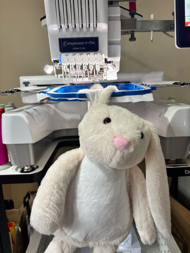 Plush bunny being personalised on an embroidery machine. 